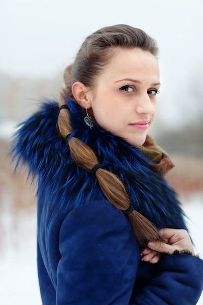 Fille en manteau bleu en hiver