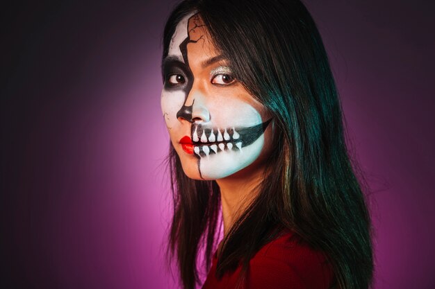 Fille avec maquillage et masque de halloween à la recherche de côté