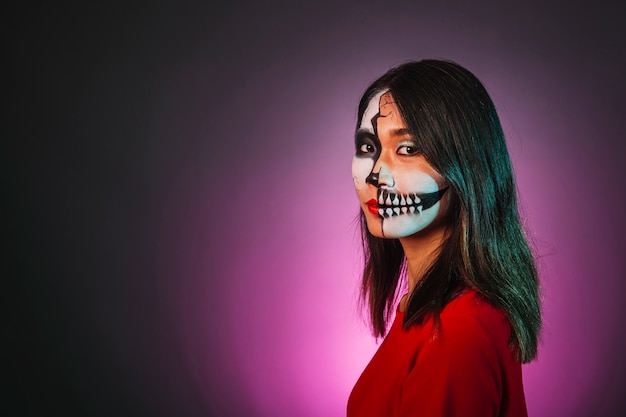 Fille avec maquillage et masque de halloween regardant vers le côté