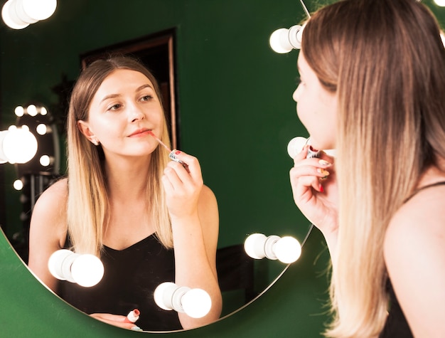 Photo gratuite fille la maquillant dans une chambre verte