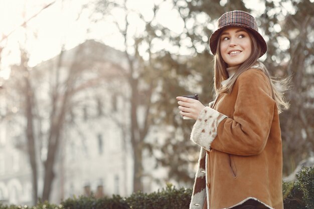 Fille marchant dans une ville de printemps et prenant du café