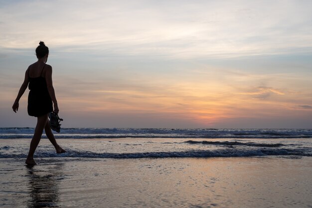 Fille marchant sur l'eau sur une plage