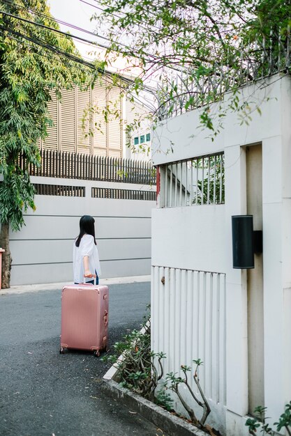 fille marche avec bagages rose