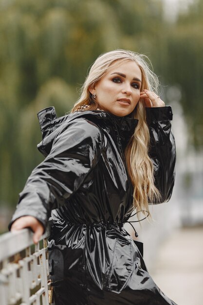 Fille marche. Femme en manteau noir.