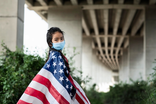 Photo gratuite fille avec masque et drapeau américain coup moyen