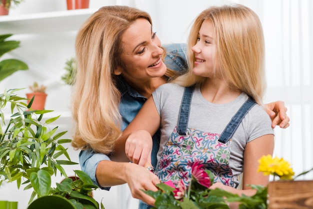 Photo gratuite fille et mère plantant des fleurs