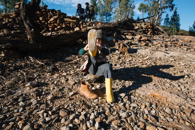 Fille mettant des bottes jaunes