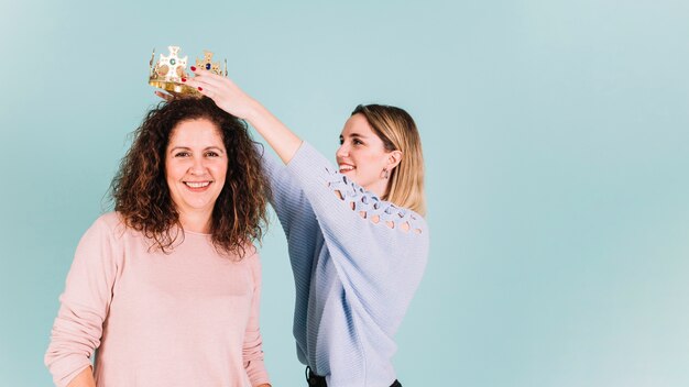 Photo gratuite fille mettant la couronne sur maman