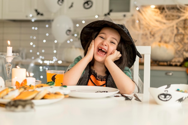 Fille mignonne et heureuse avec costume de sorcière