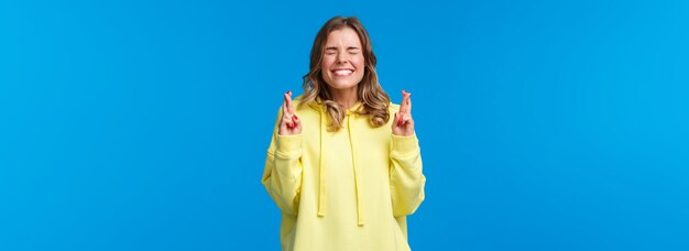 La fille a mis tout en œuvre pour prier pour que le souhait devienne réalité ferme les yeux et se mord la lèvre rêve avide de réaliser la croix