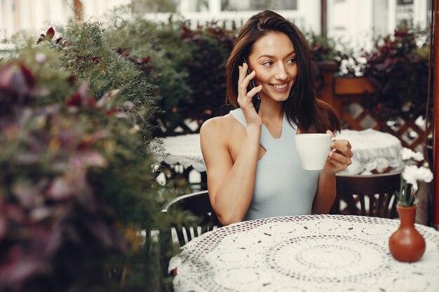 Fille de mode buvant un café dans un café