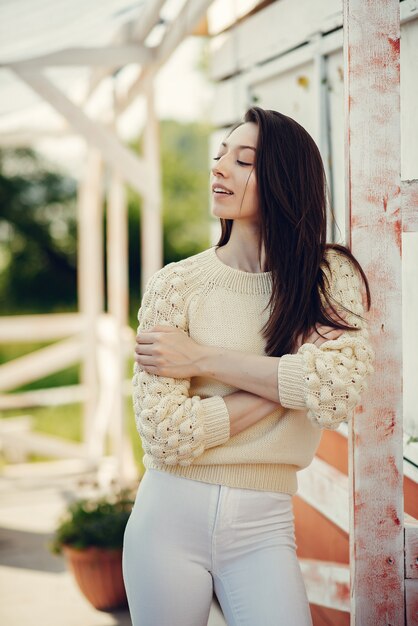 Fille de mode debout dans un parc d'été