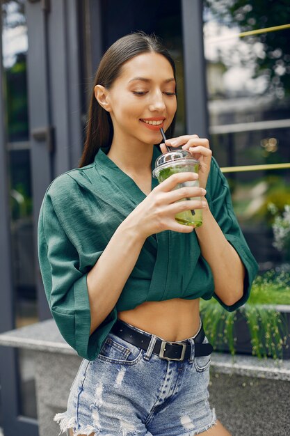 Fille de mode debout dans une ville d'été