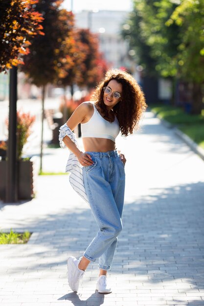 Fille de mode posant tout en portant des lunettes de soleil