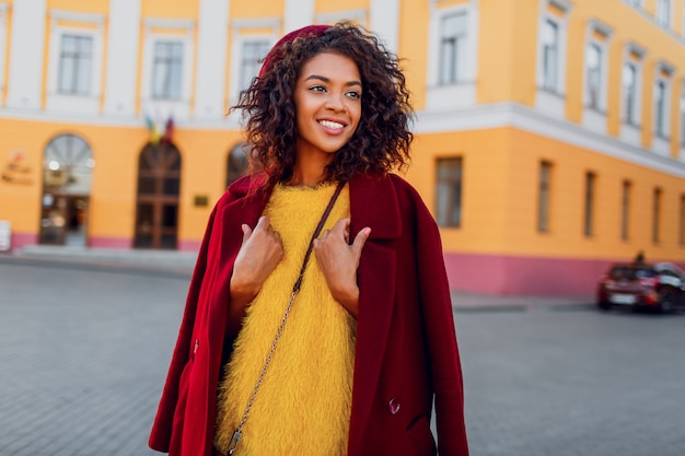 Fille à la mode en tenue d'hiver incroyable et accessoires posant sur jaune