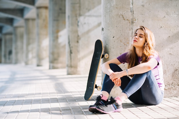 Photo gratuite fille modelant avec un skateboard