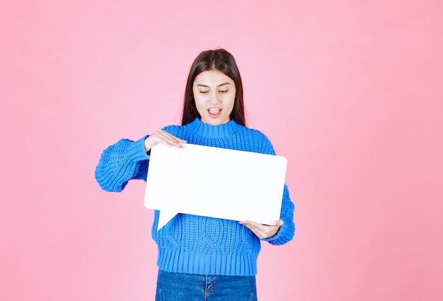 fille montrant la bannière de la bulle de la parole et l'air heureux sur le rose.