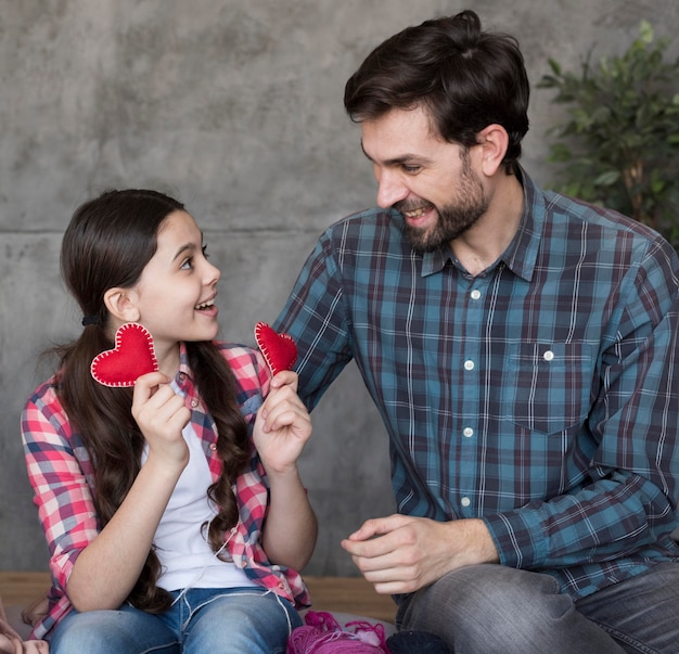 Photo gratuite fille montrant les coeurs de papa