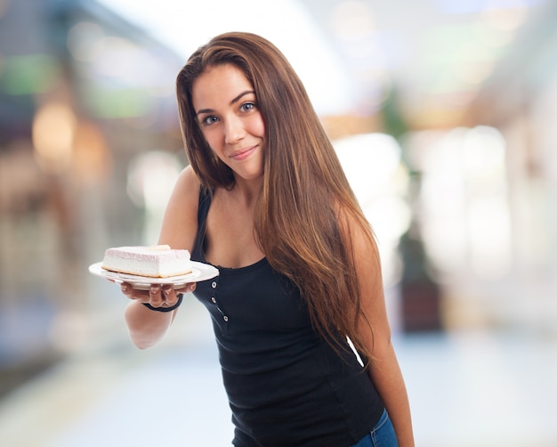 Fille montrant le gâteau crémeux sur la plaque.