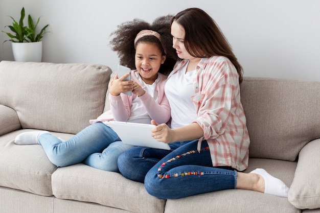 Fille montrant quelque chose au téléphone à la mère