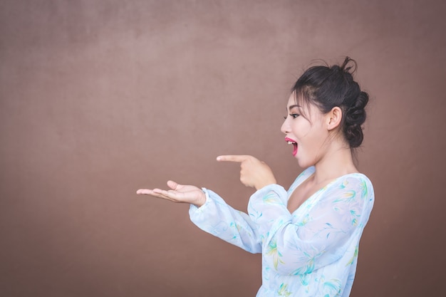 La fille montre des gestes de la main et des émotions faciales.