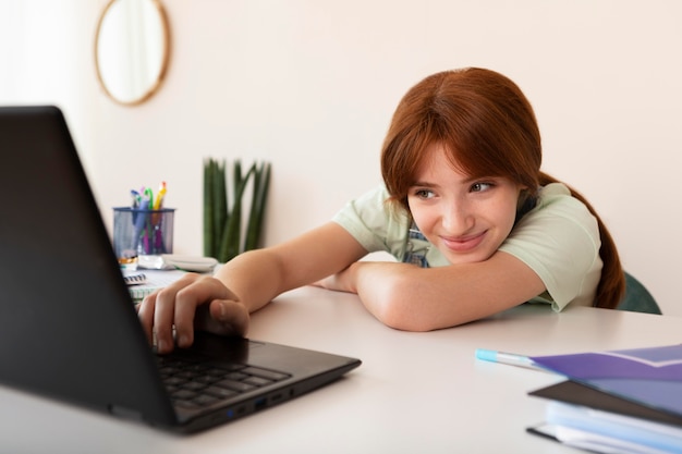 Photo gratuite fille moyenne qui étudie avec un ordinateur portable