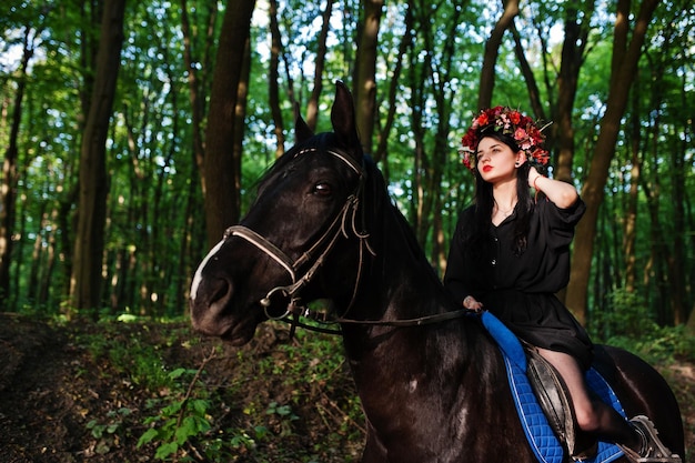 Fille mystique en guirlande en noir à cheval en bois