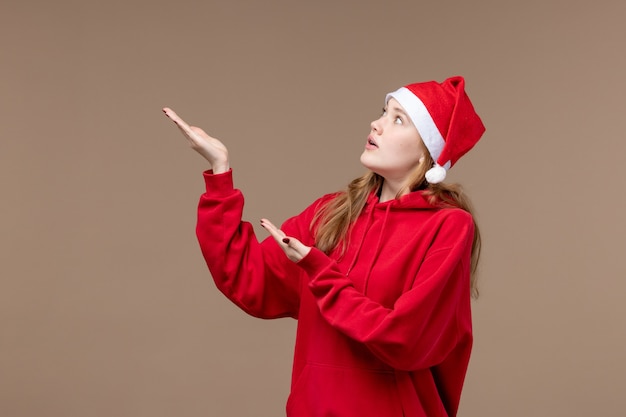 Fille de Noël vue de face avec visage nerveux sur espace brun