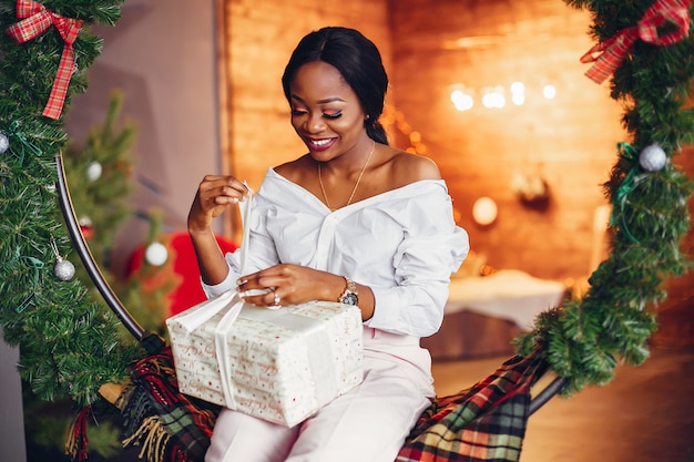 Fille noire élégante dans les décorations de Noël