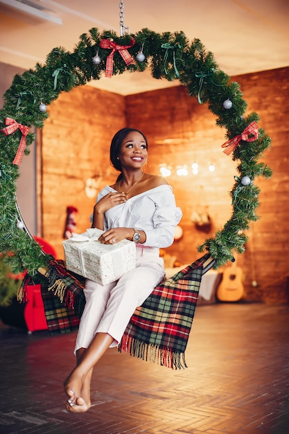 Fille noire élégante dans les décorations de Noël