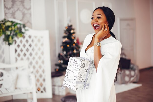 Fille noire élégante dans la salle décorée de Noël