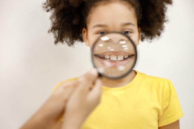 Photo gratuite fille noire tenant une loupe près de sa bouche