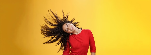 Photo gratuite fille obtenant des cheveux insouciants et sauvages et faisant du soleil avec des boucles volant dans l'air souriant largement t