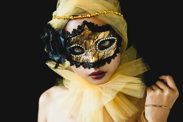 Fille avec un ornement jaune sur la tête et un masque vénitien