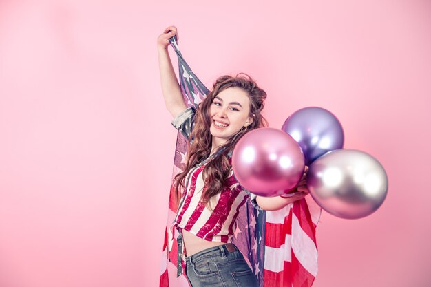 Fille patriotique avec le drapeau de l'Amérique sur un fond coloré