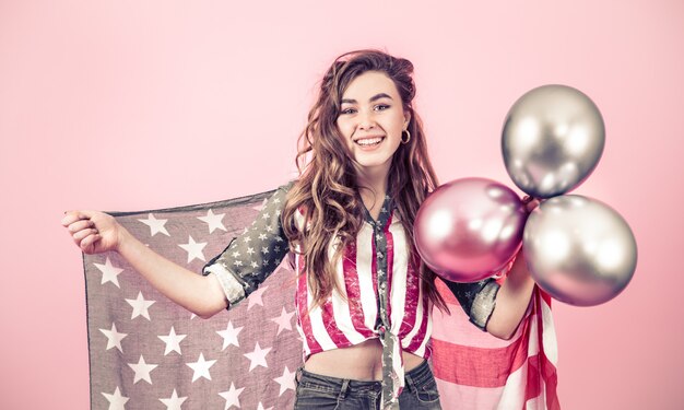 Fille patriotique avec le drapeau de l'Amérique sur un mur coloré