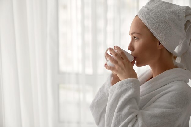 Fille en peignoir buvant une tasse de café