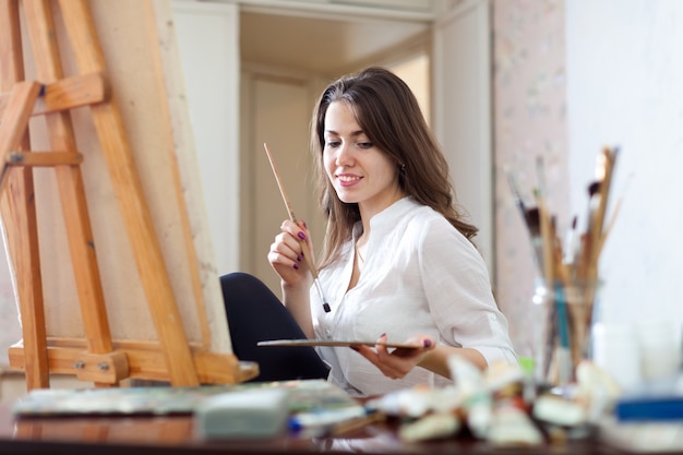 La fille peint sur toile avec des couleurs huile