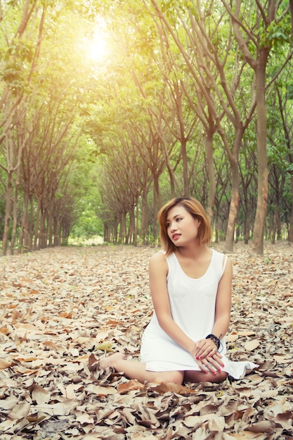 fille Pensive assis sur des feuilles sèches