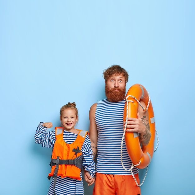 Photo gratuite fille et père aux cheveux roux posent avec un équipement de natation