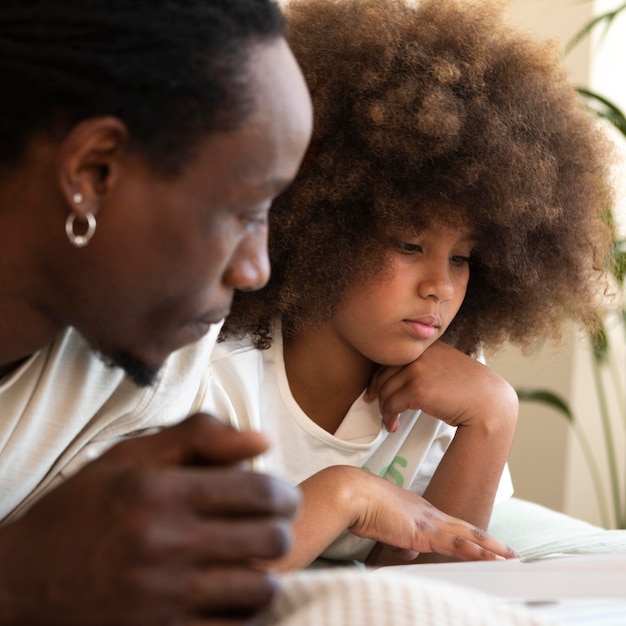 Fille et père lisant un livre ensemble