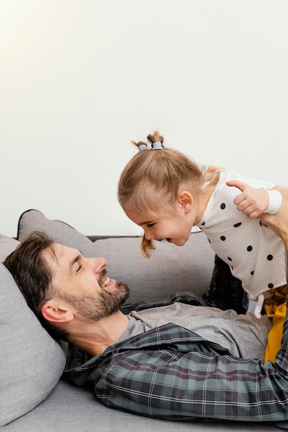 Photo gratuite fille de plan moyen et père à la maison