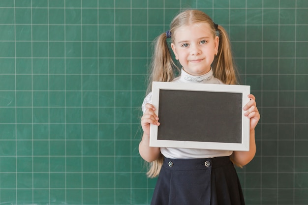 Photo gratuite fille avec plaque de panneau près du tableau