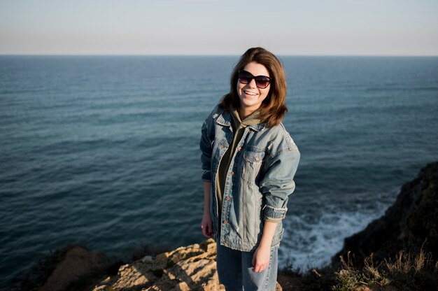 Fille portant des lunettes de soleil et l'océan