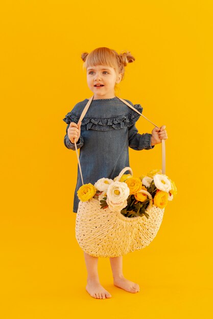 Fille portant un panier de fleurs