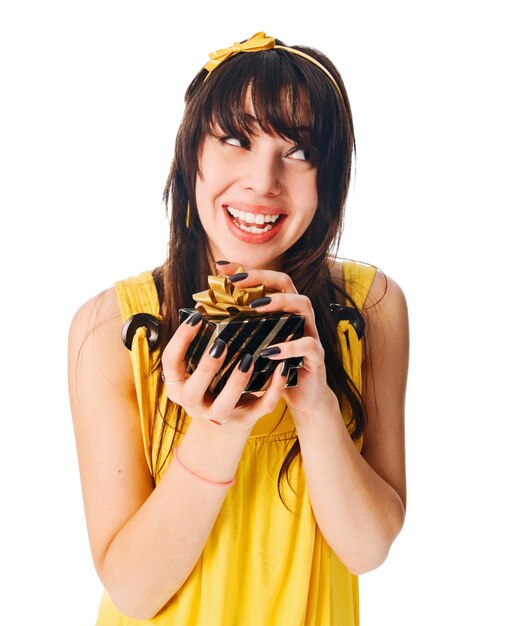 Fille portant une robe jaune avec une boîte cadeau