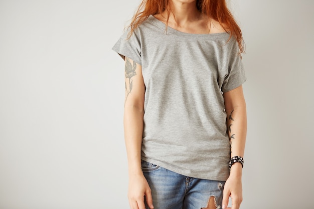 Fille portant un t-shirt blanc gris debout sur un mur blanc