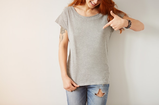 Fille portant un t-shirt blanc gris debout sur un mur blanc