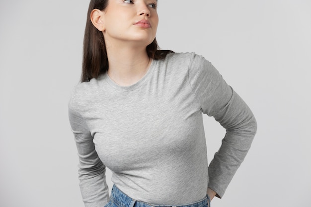 Fille portant un t-shirt gris posant en studio