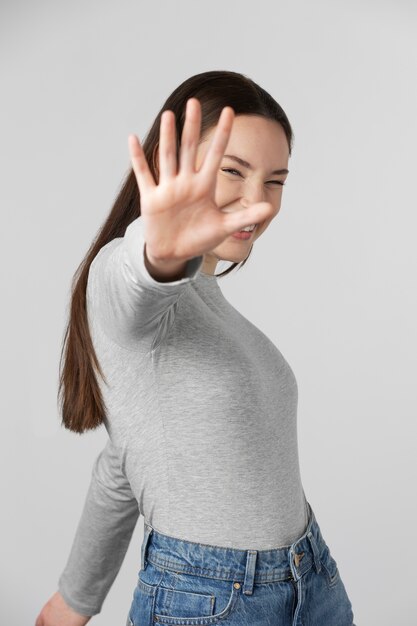 Fille portant un t-shirt gris posant en studio